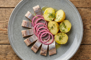 Селедка с маринованным красным луком и отварным картофелем.